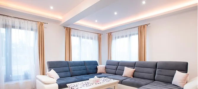 Wohnzimmer mit indirekter LED-Deckenbeleuchtung und Einbaustrahlern