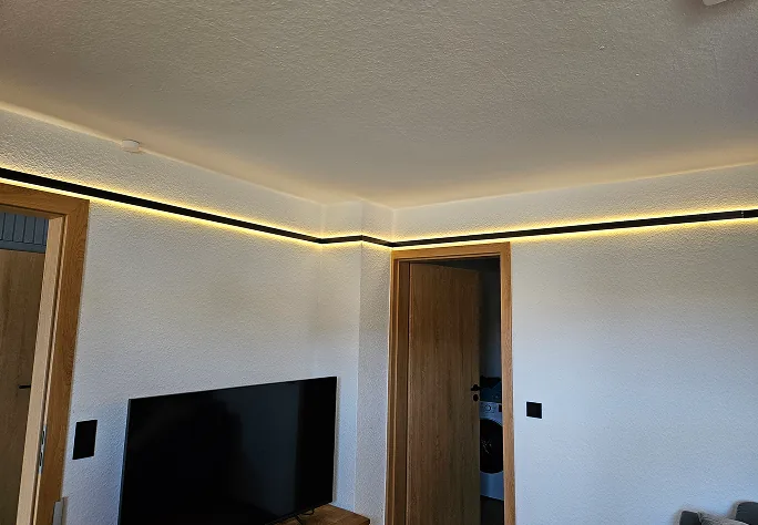 Wohnraum mit umlaufender indirekter LED-Beleuchtung unter der Decke