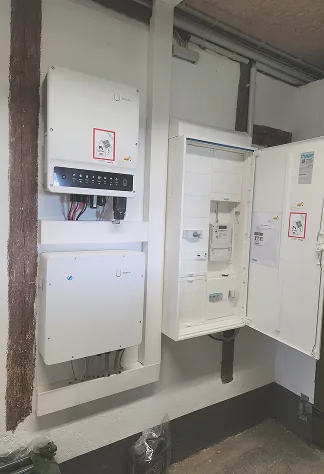 Wechselrichter, Batteriespeicher und geöffneter Zählerschrank an der Wand