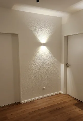 Flur mit Wandleuchte, die Licht nach oben und unten wirft