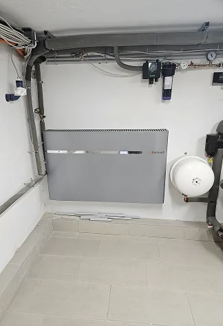 Technikraum mit wandmontiertem Batteriespeicher und Rohrleitungen