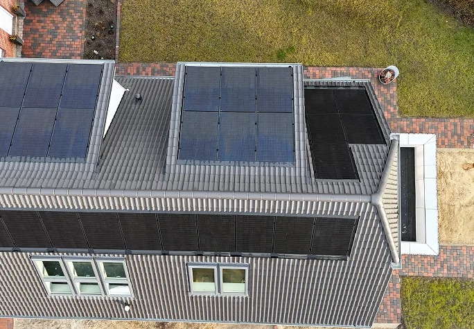 Luftaufnahme eines Hausdachs mit schwarzen Solarmodulen